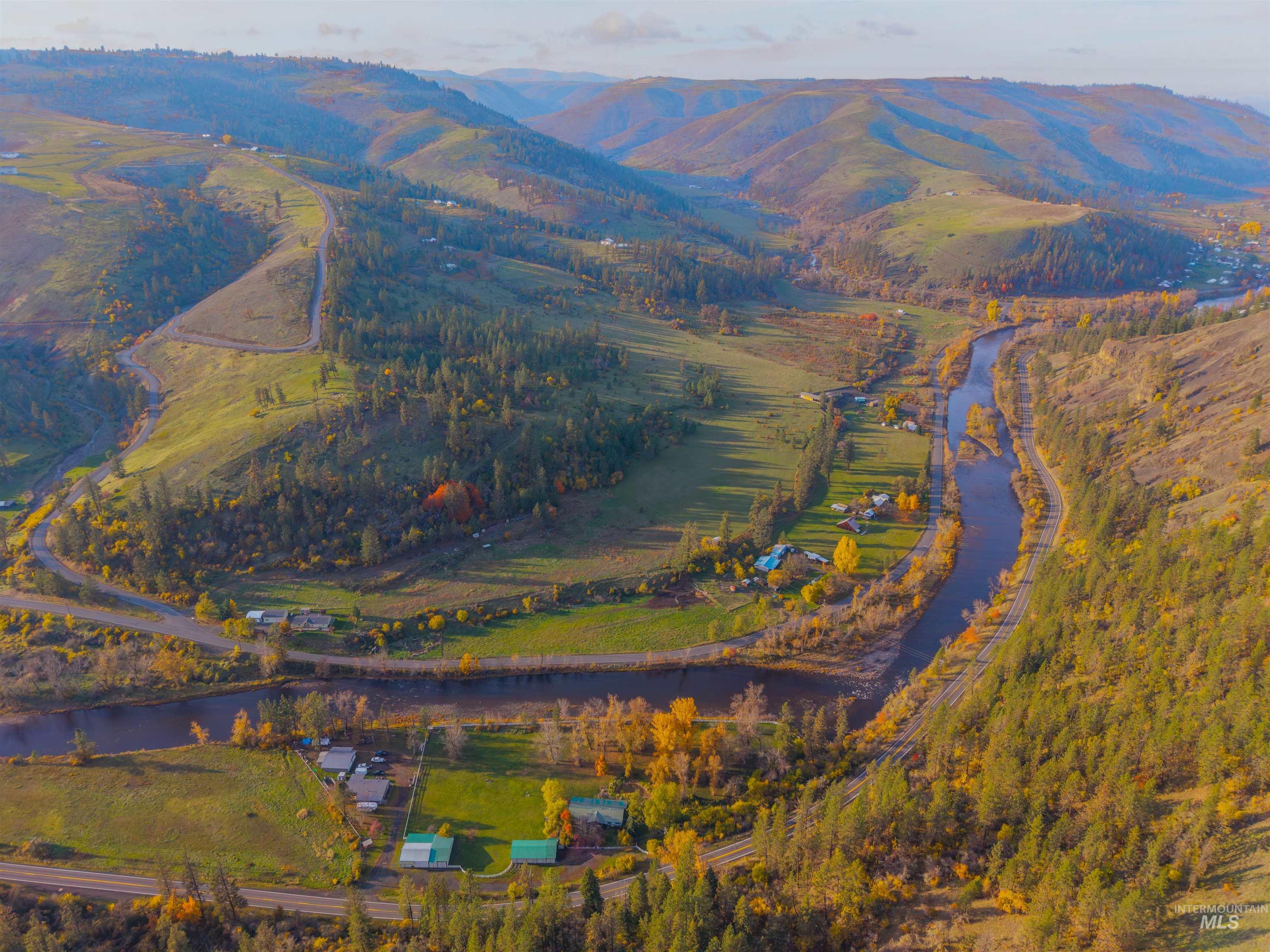 Aerial view of property and surrounding area featuring a water and mountain view