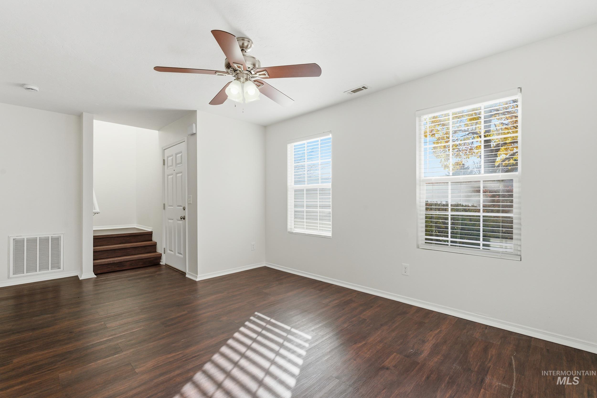 Spare room with dark wood finished floors and a ceiling fan