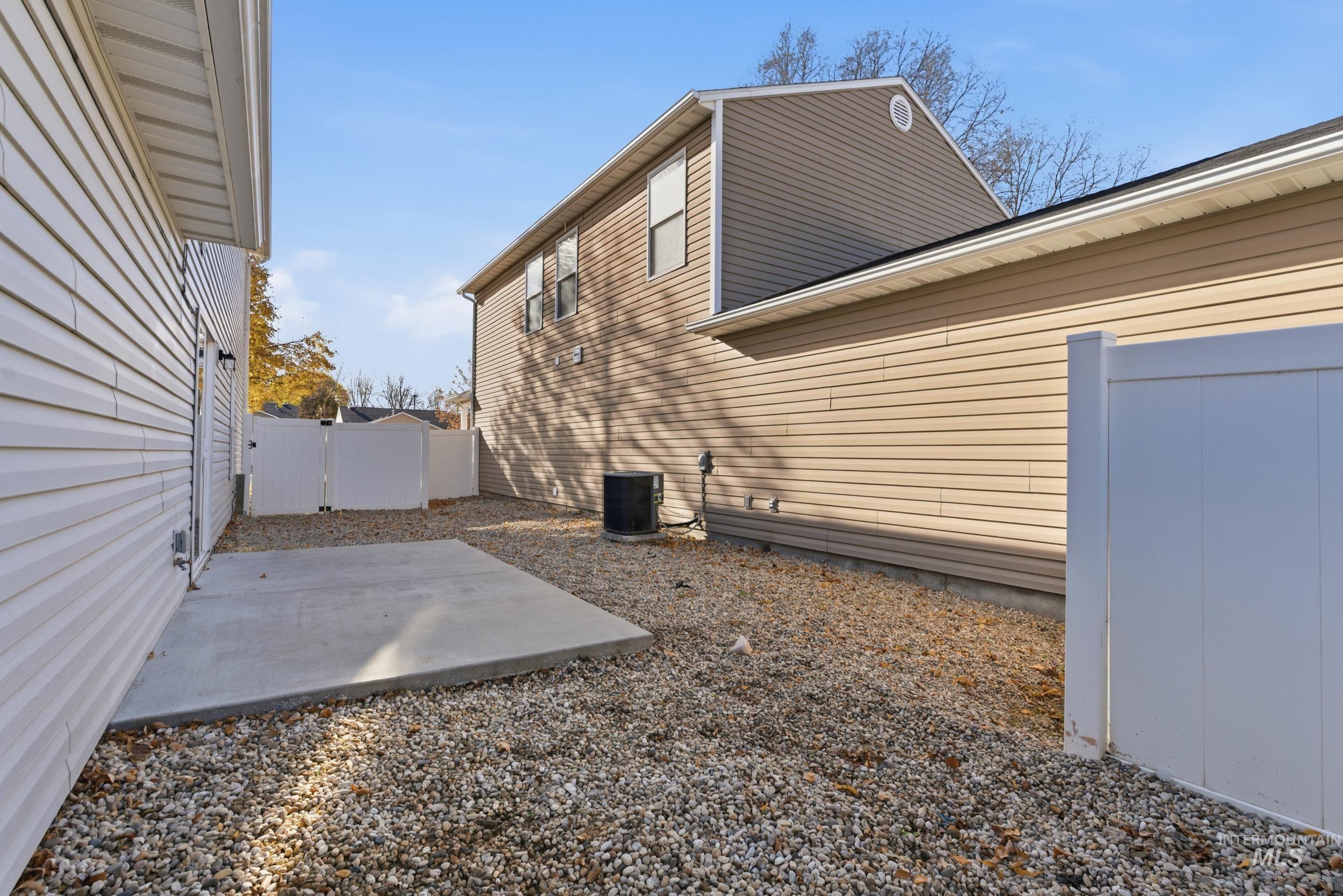 View of home's exterior with a fenced backyard and a patio area