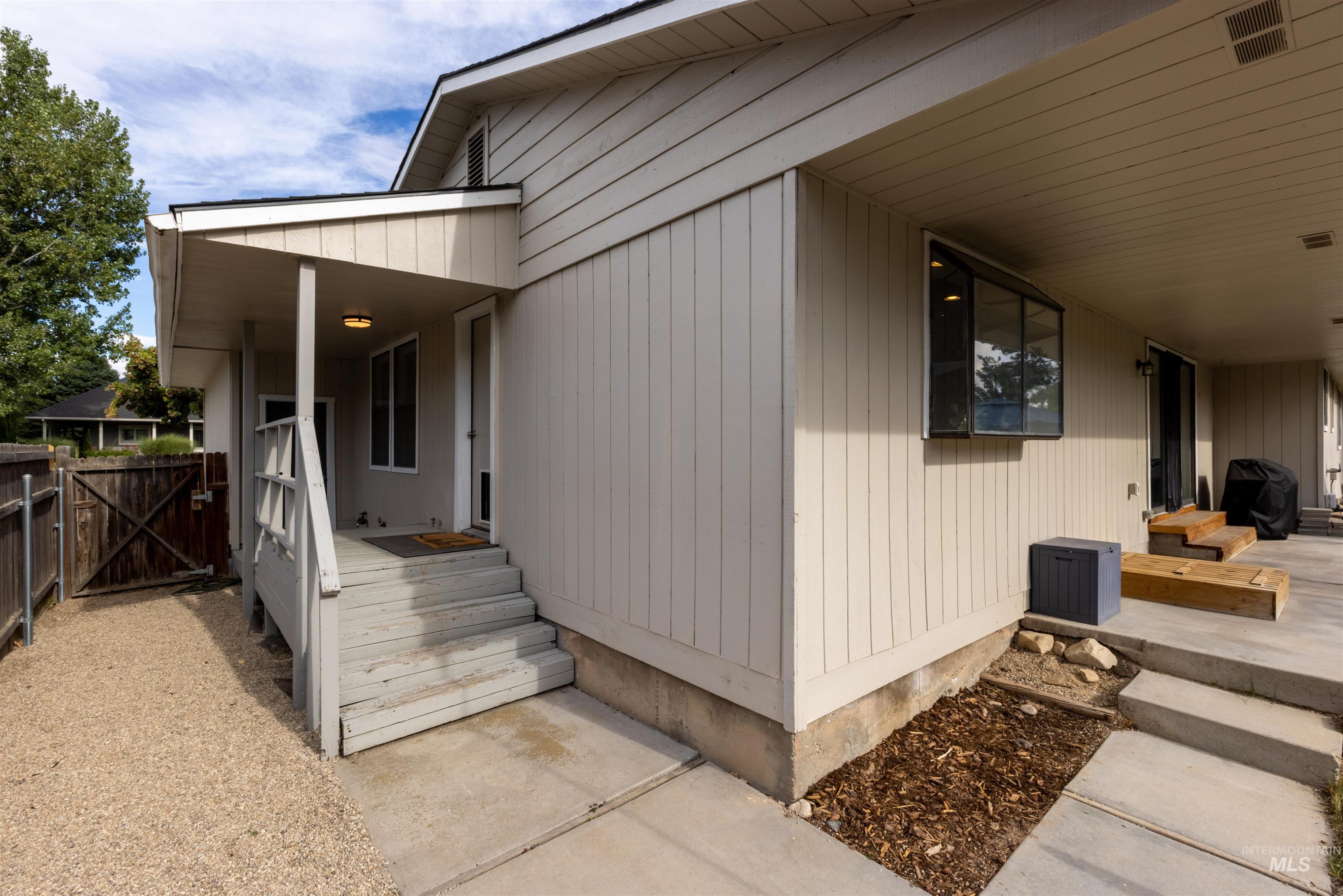View of side of home featuring a gate