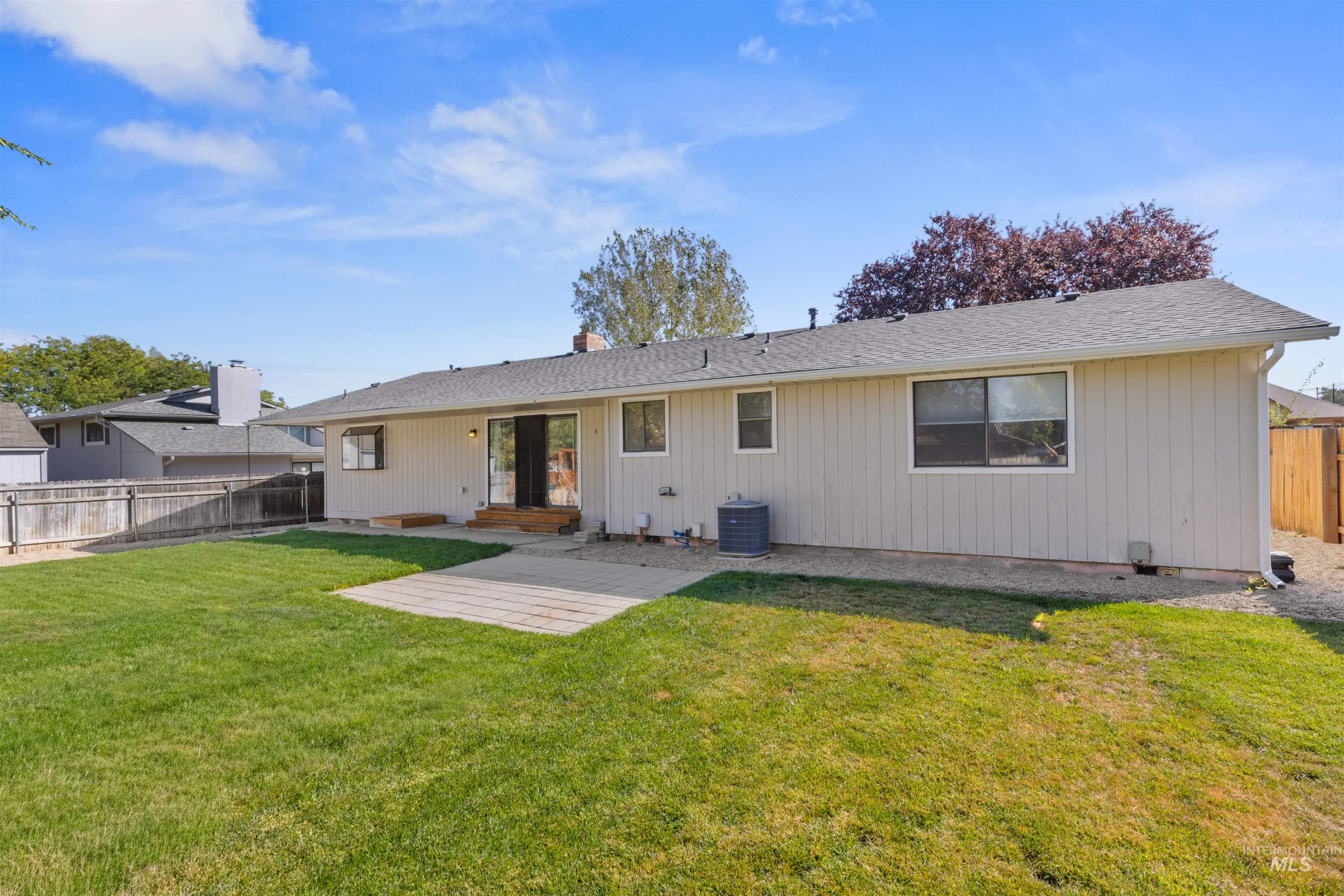 Back of property with a fenced backyard, a patio, and roof with shingles