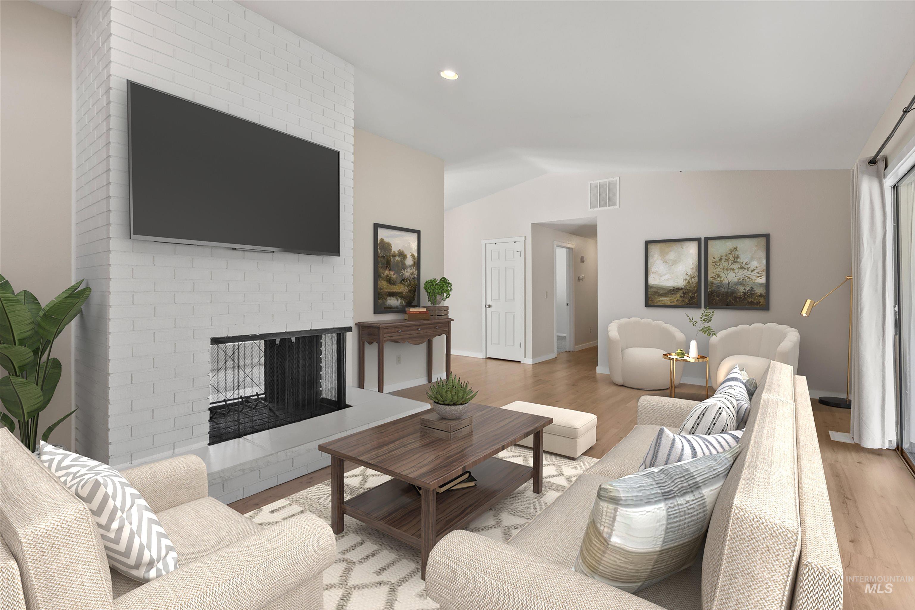 Living room featuring a fireplace, vaulted ceiling, wood finished floors, and recessed lighting