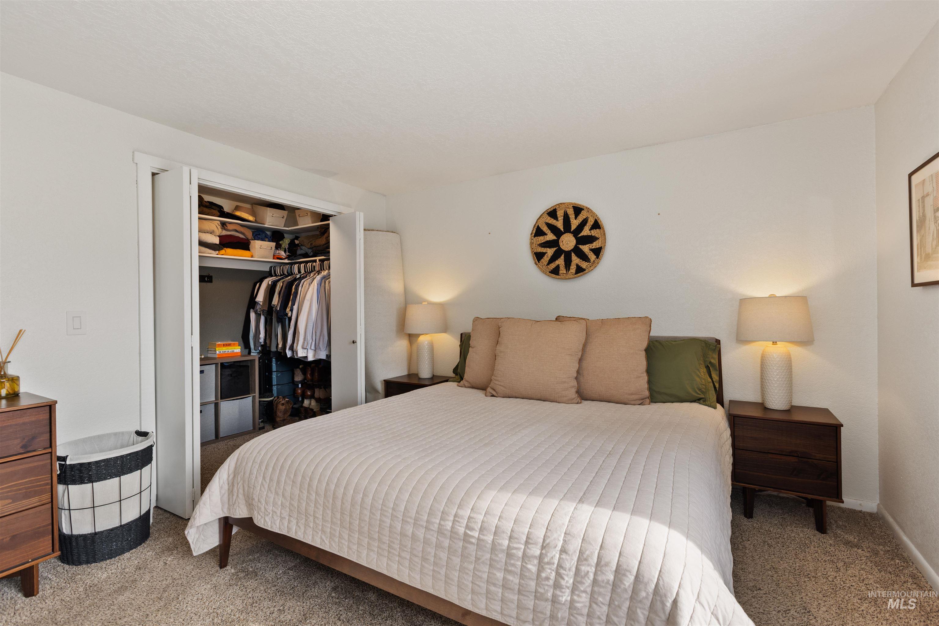Carpeted bedroom featuring a closet and baseboards