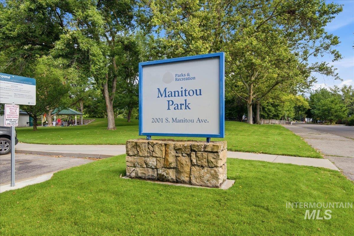 Manitou Park sign on a stone base, surrounded by green lawns and mature trees