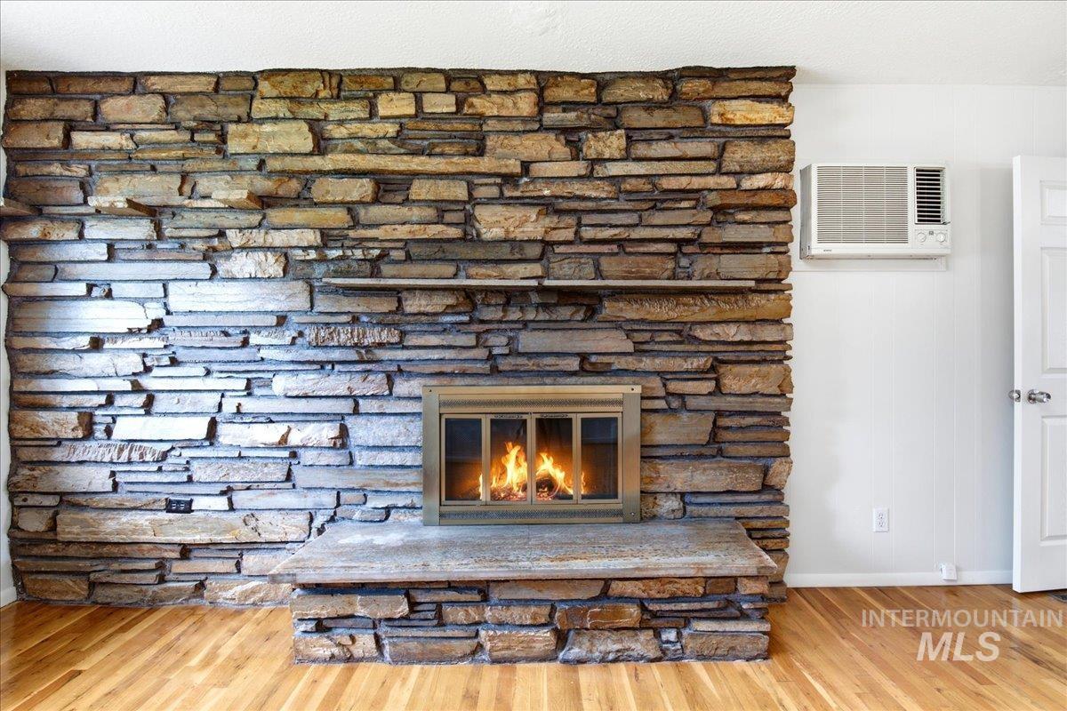 Stacked stone fireplace with a metal insert and stone hearth