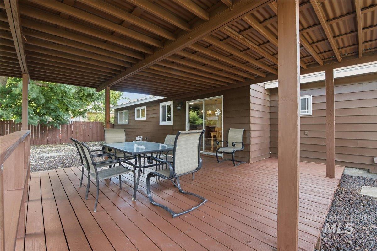Expansive covered deck featuring a wood-finish floor, wood ceiling, and direct access to the interior through a sliding glass door