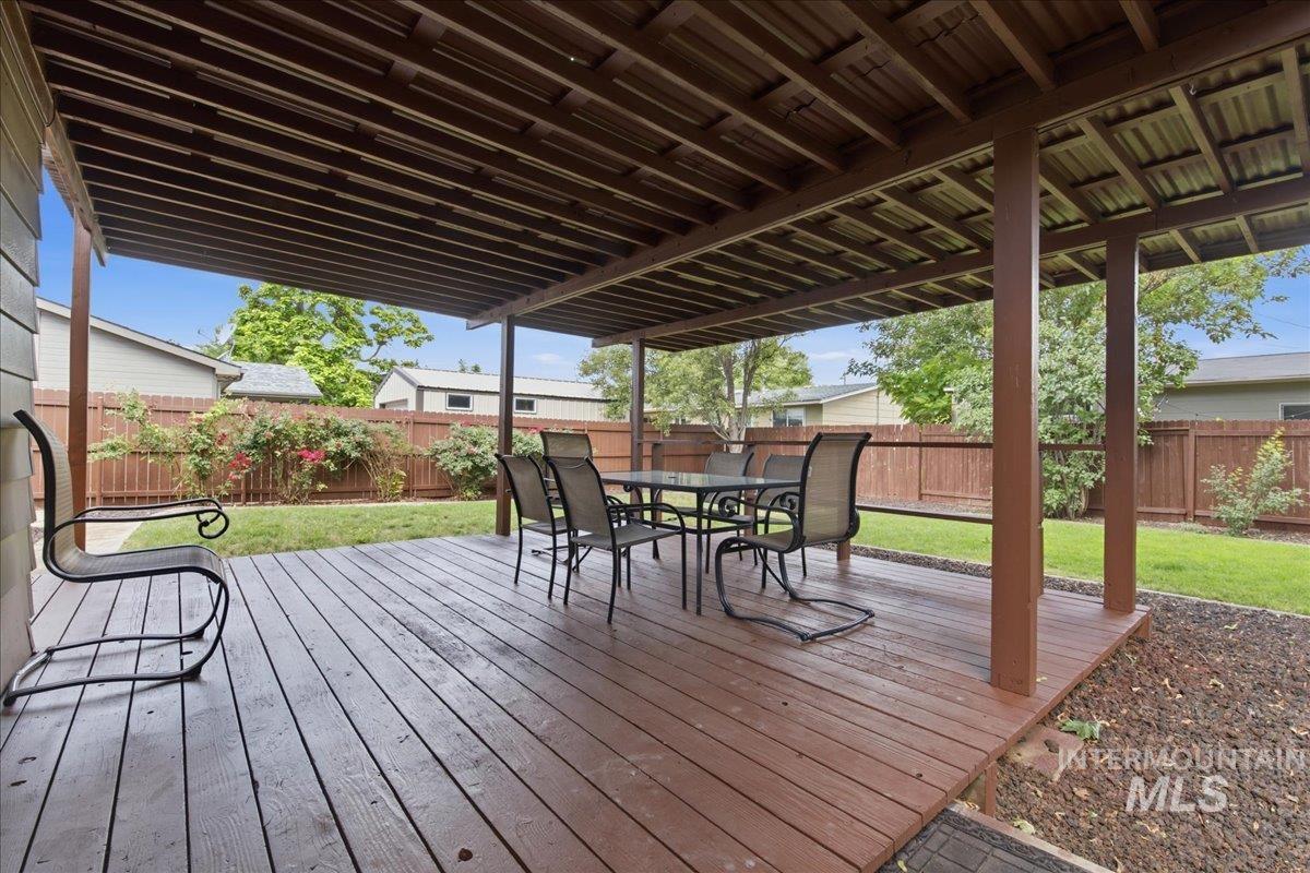 Expansive covered deck featuring wood-finish flooring and a slatted ceiling