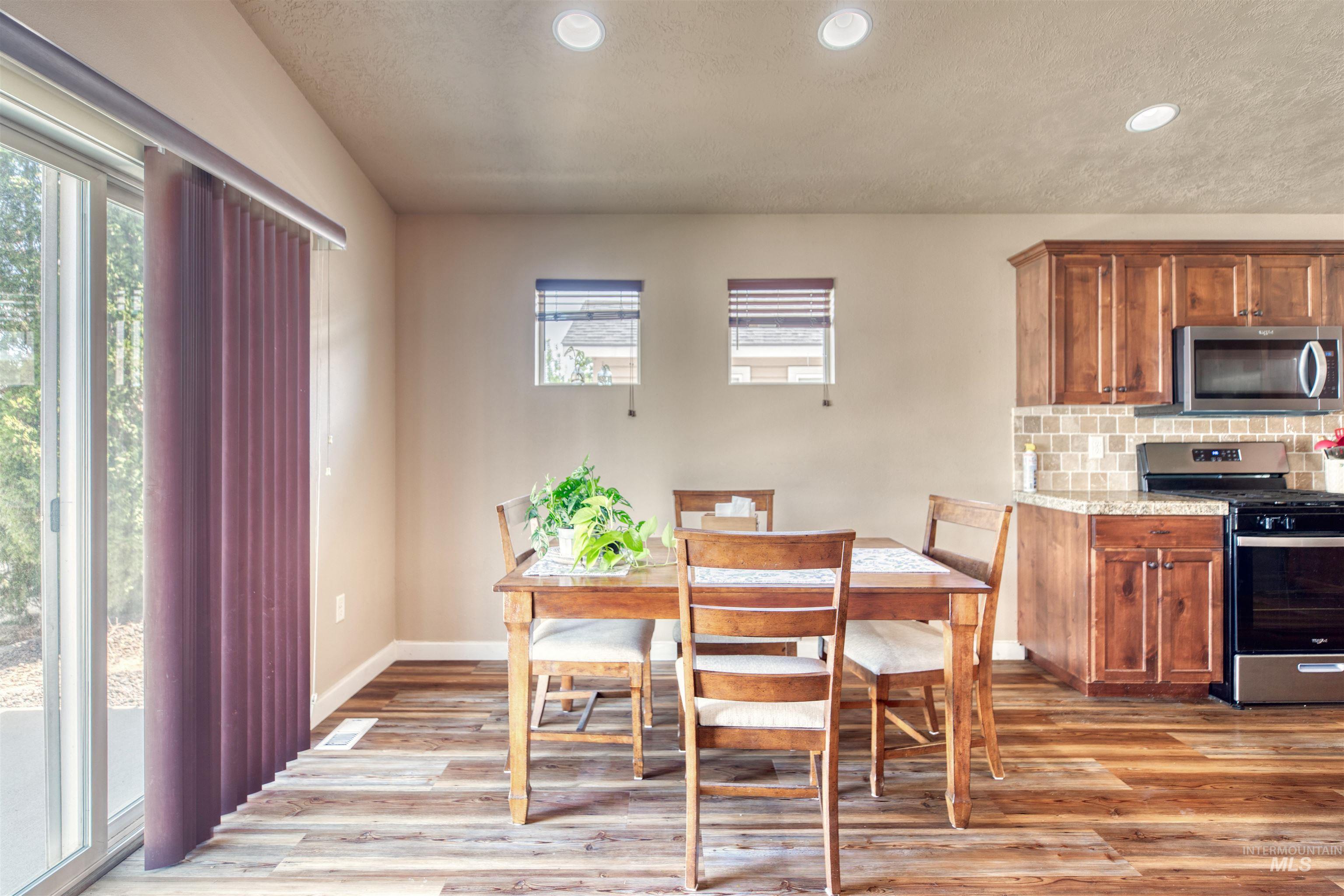 Dining space with light wood finished floors, a textured ceiling, and recessed lighting