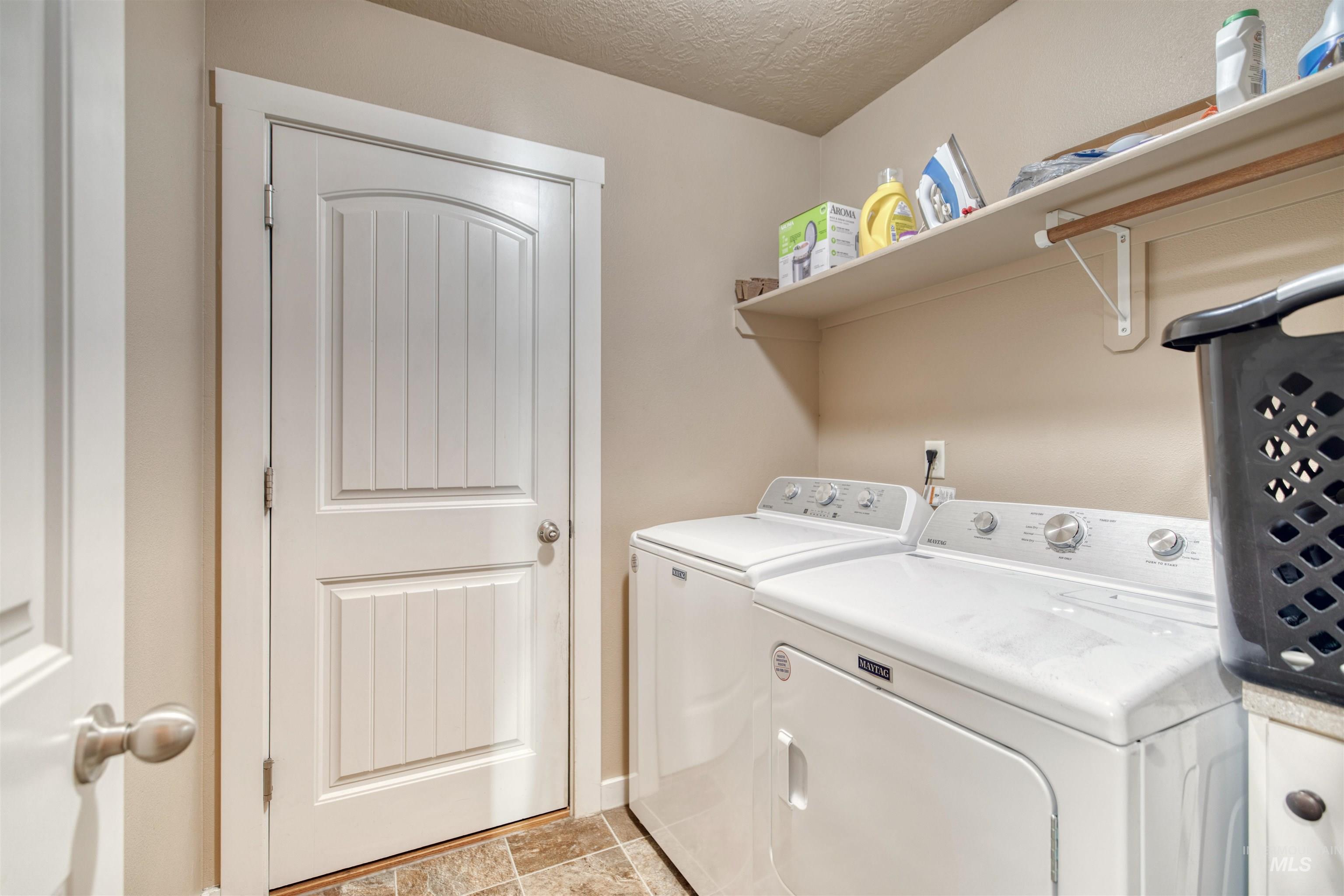 Laundry room featuring independent washer and dryer and a textured ceiling