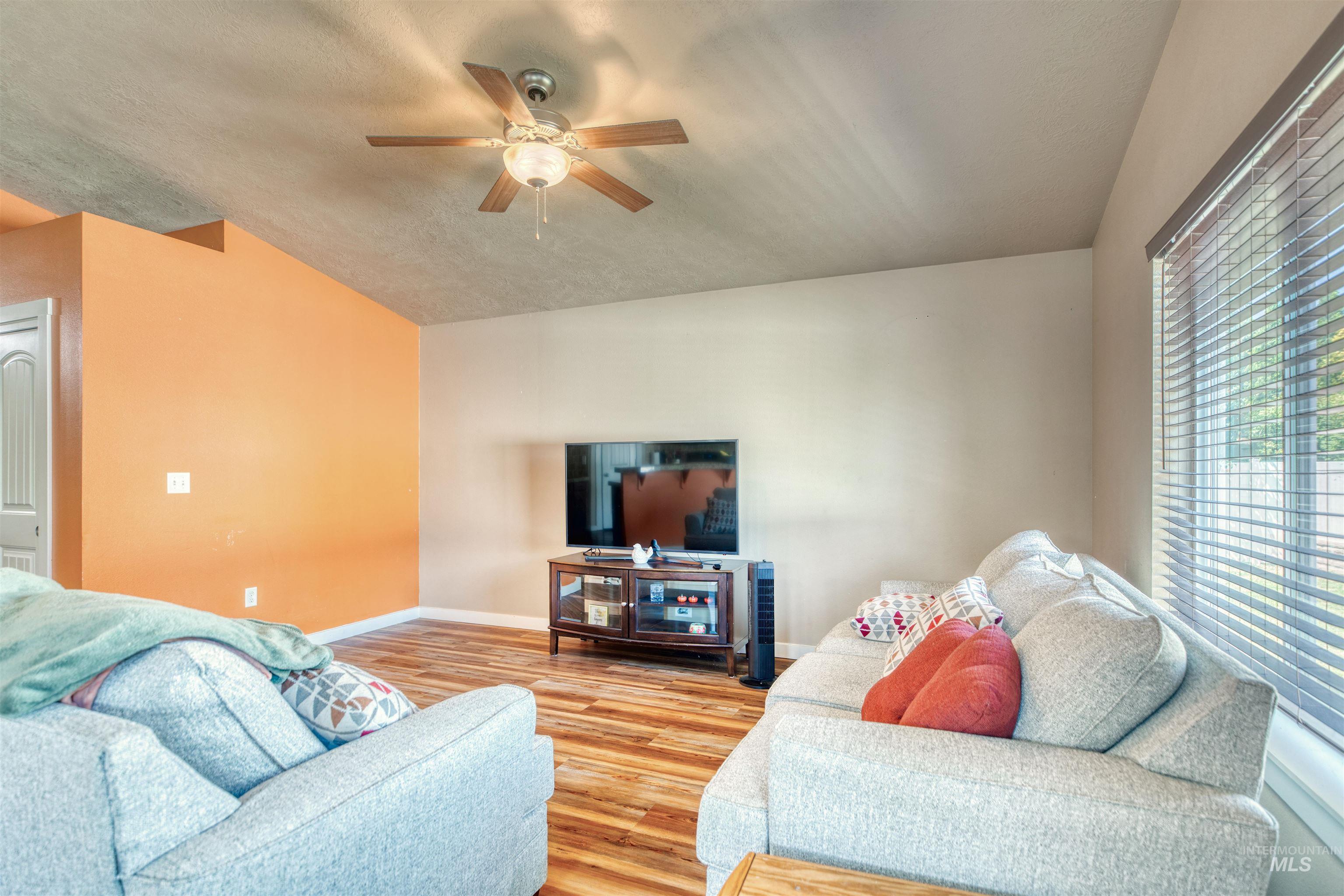 Living area with wood finished floors, ceiling fan, and a textured ceiling