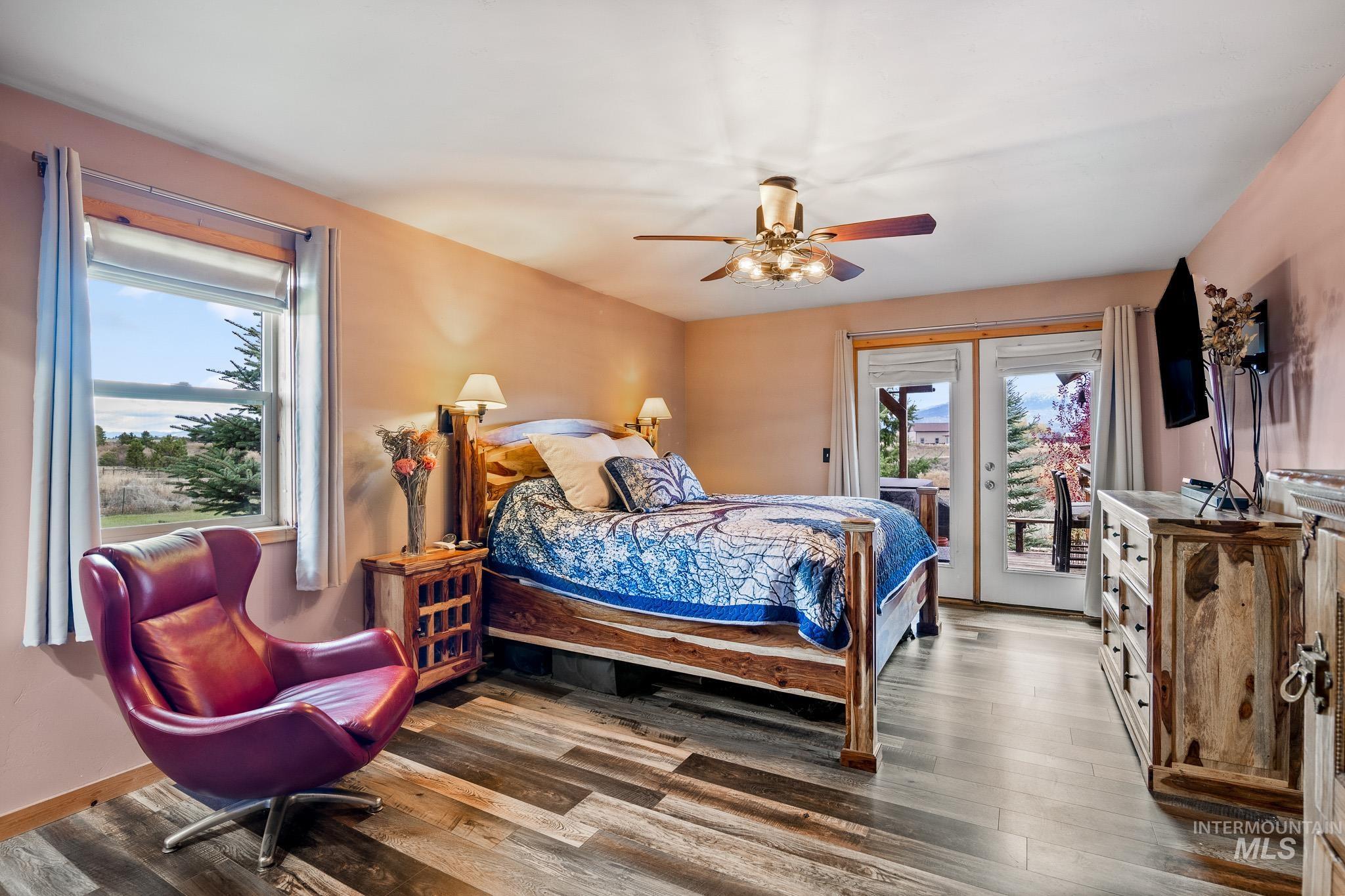 Master bedroom featuring access to exterior, large walk in closet and ceiling fan