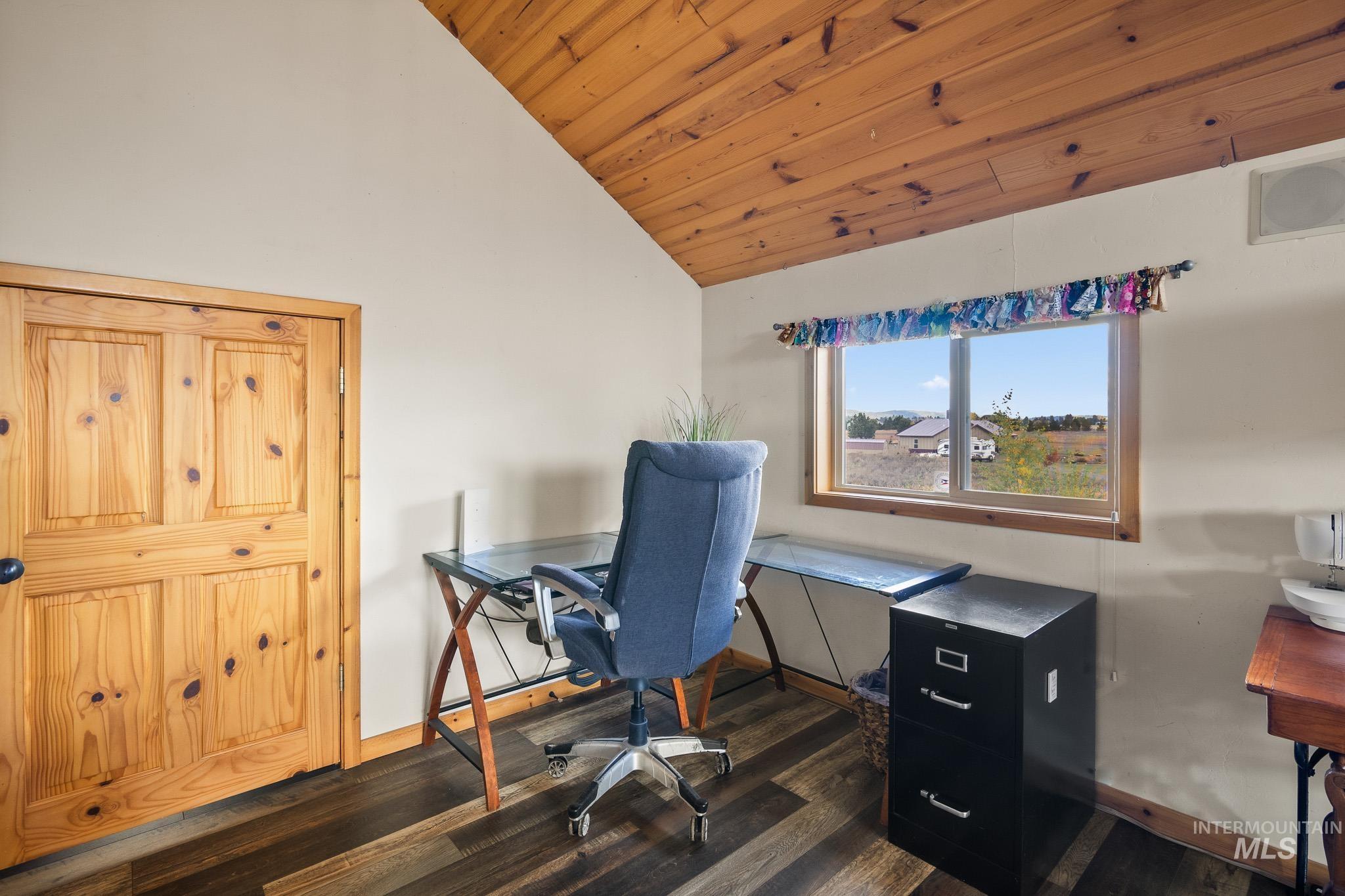 Home office featuring dark wood-style flooring, lofted ceiling, and wood ceiling