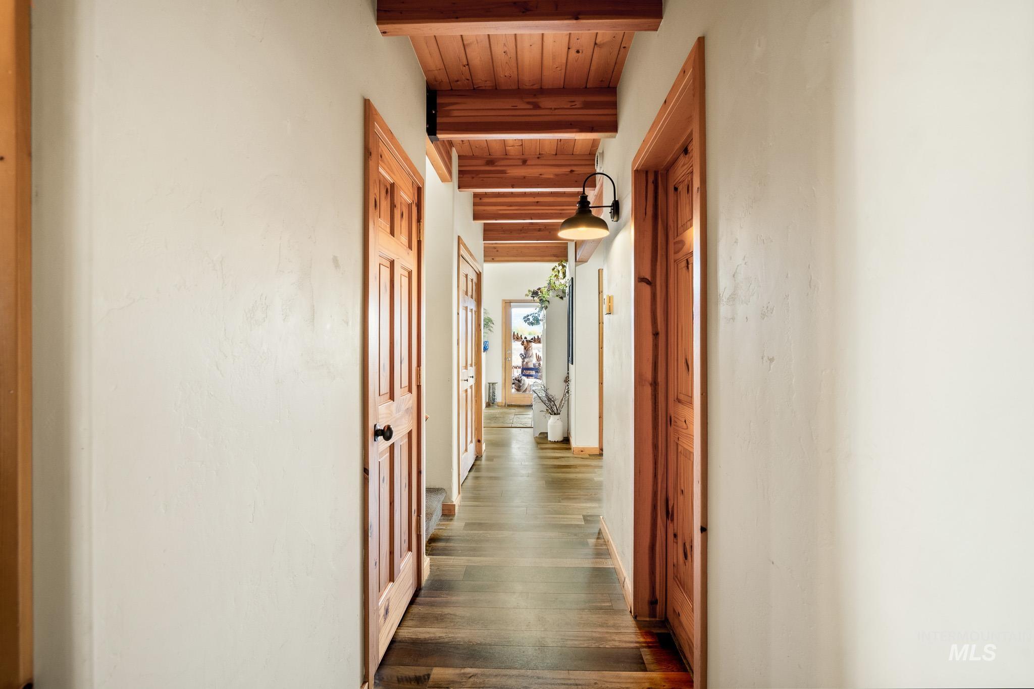 Corridor with a wood ceiling with exposed beams and engineered vinyl plank flooring