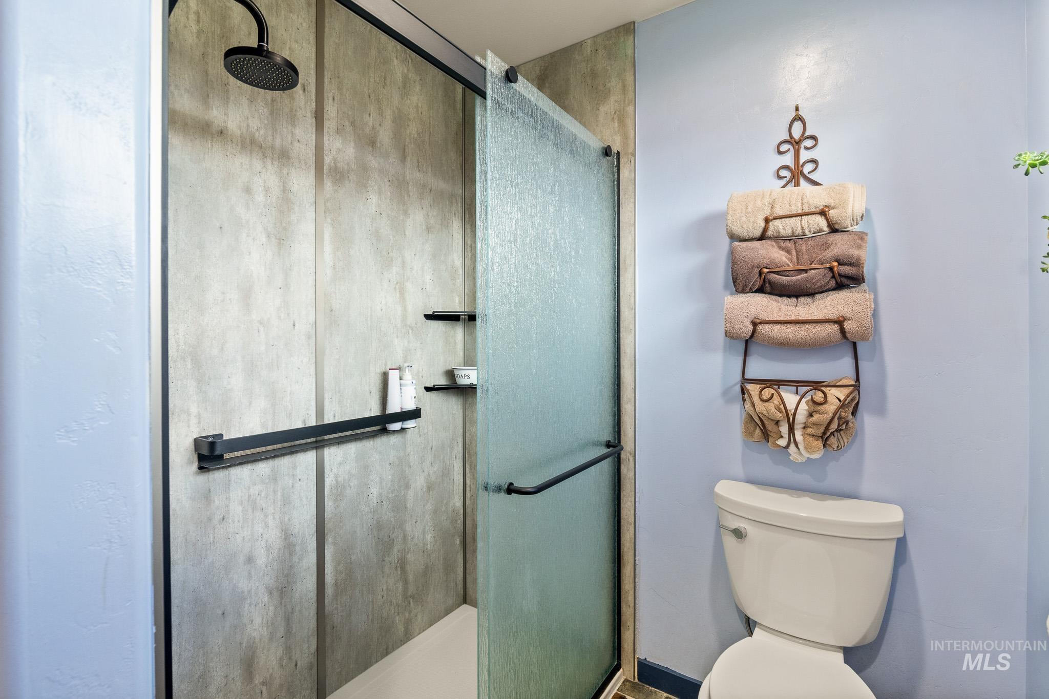 Full bathroom featuring a stall shower and toilet