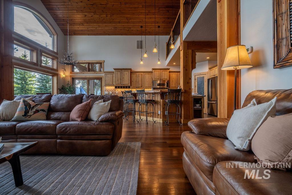 Spacious living area featuring expansive windows, wood-finish flooring, and a natural wood plank ceiling
