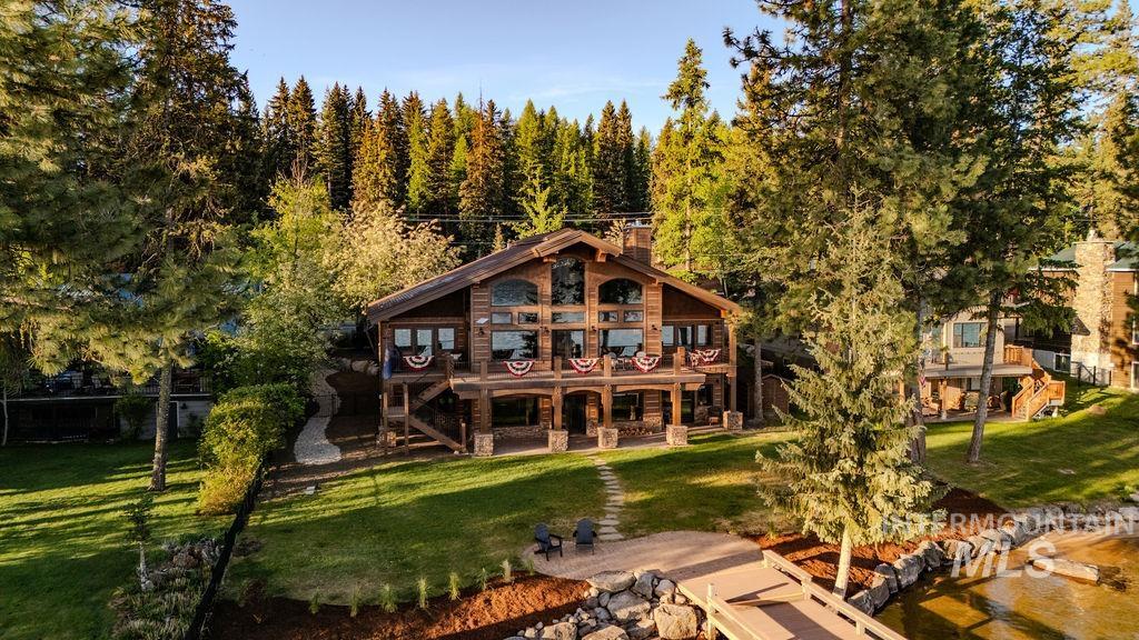 Rustic-style log home featuring extensive glazing and a full-width balcony