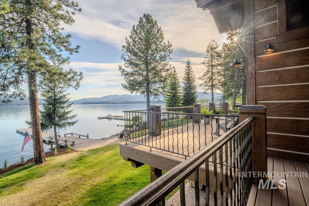 Expansive outdoor deck with a sturdy metal railing, providing a direct water frontage with a private dock