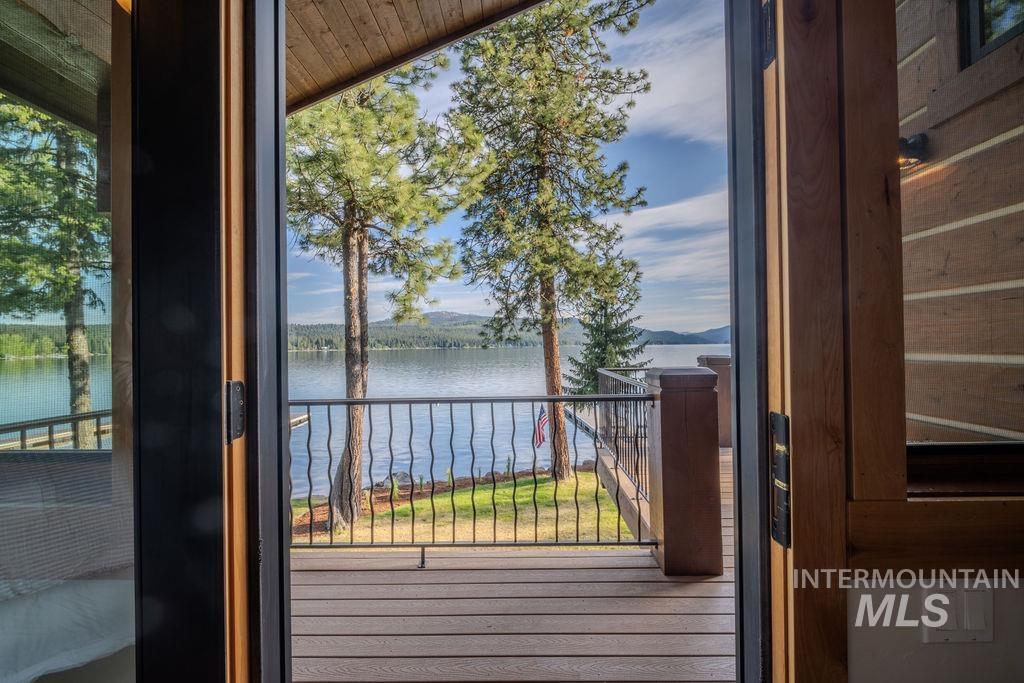 Sliding glass doors opening to a wood-finish deck with wrought iron railing