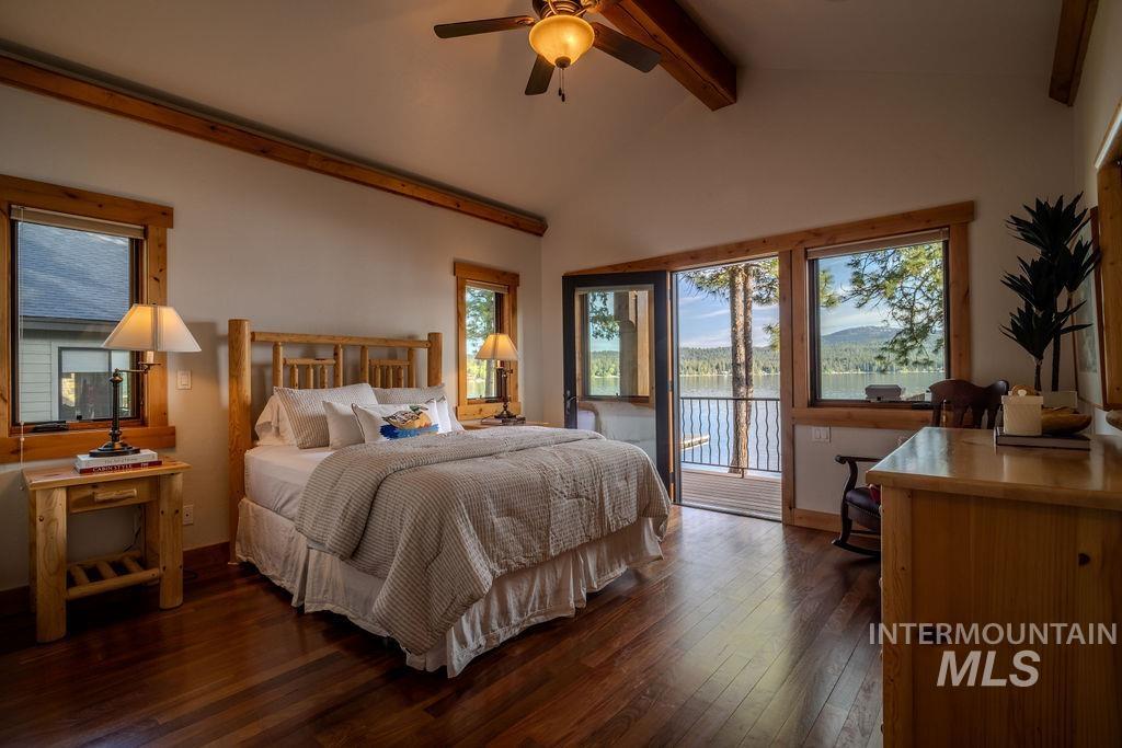 Wood-finish flooring throughout, featuring a vaulted ceiling with exposed wood beams and a ceiling fan