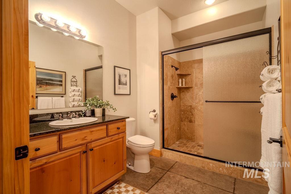 Bathroom featuring a wood-finish vanity with a dark countertop and undermount sink