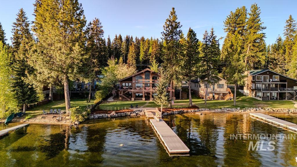 Waterfront property featuring multiple boat docks and a manicured lawn