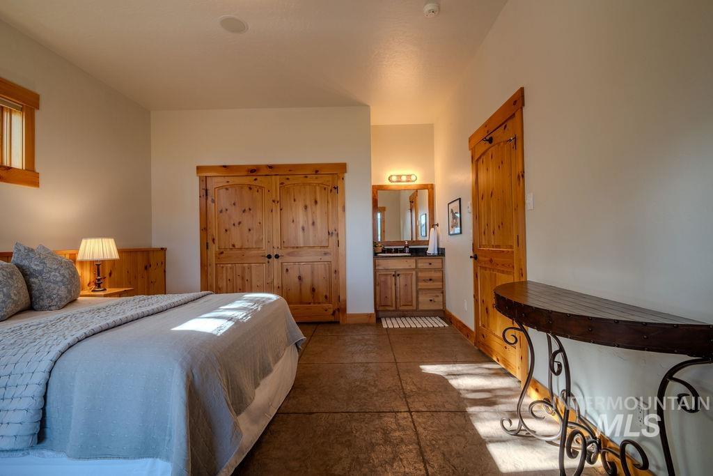 Bedroom space featuring textured flooring, natural wood doors, and a built-in vanity with a sink