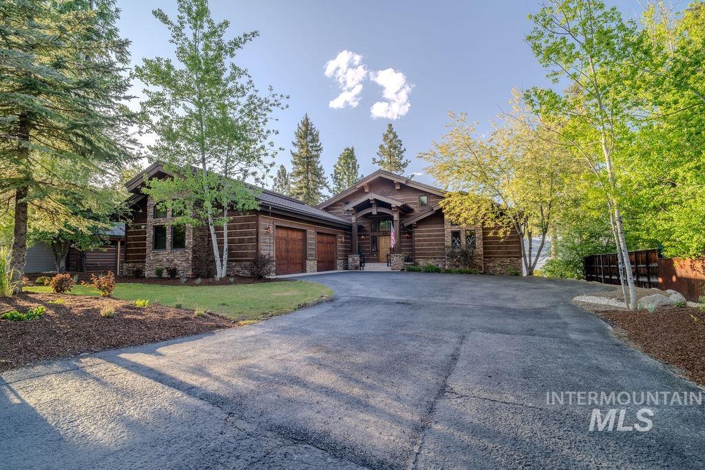 Rustic-style residence featuring log siding and stone accents