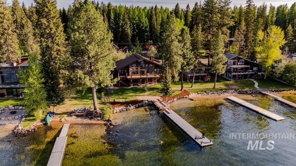 Waterfront property featuring multiple private docks and a sandy shoreline