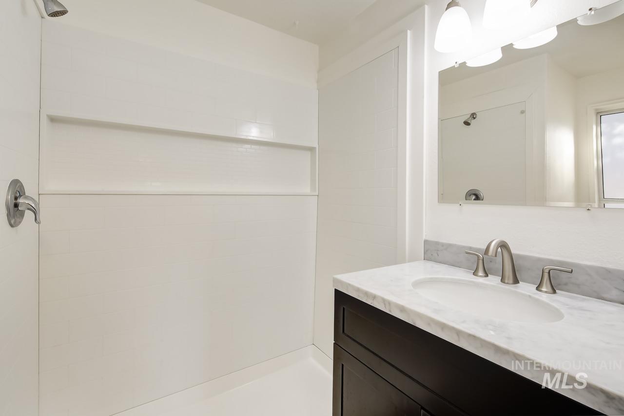 Full bathroom featuring vanity and tiled shower