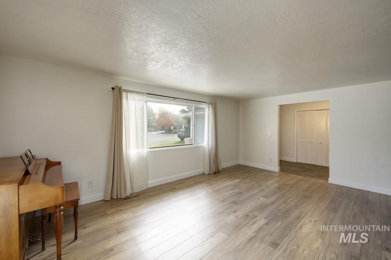 Unfurnished living room featuring a textured ceiling and light wood finished floors