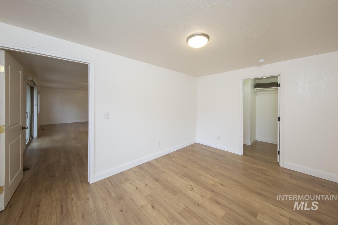 Unfurnished room with light wood-style flooring and baseboards