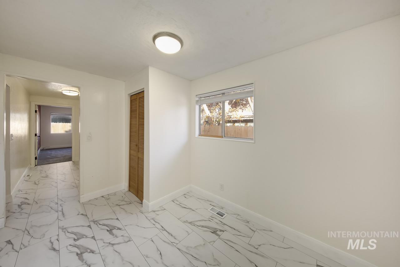 Unfurnished room with light marble finish floors and baseboards