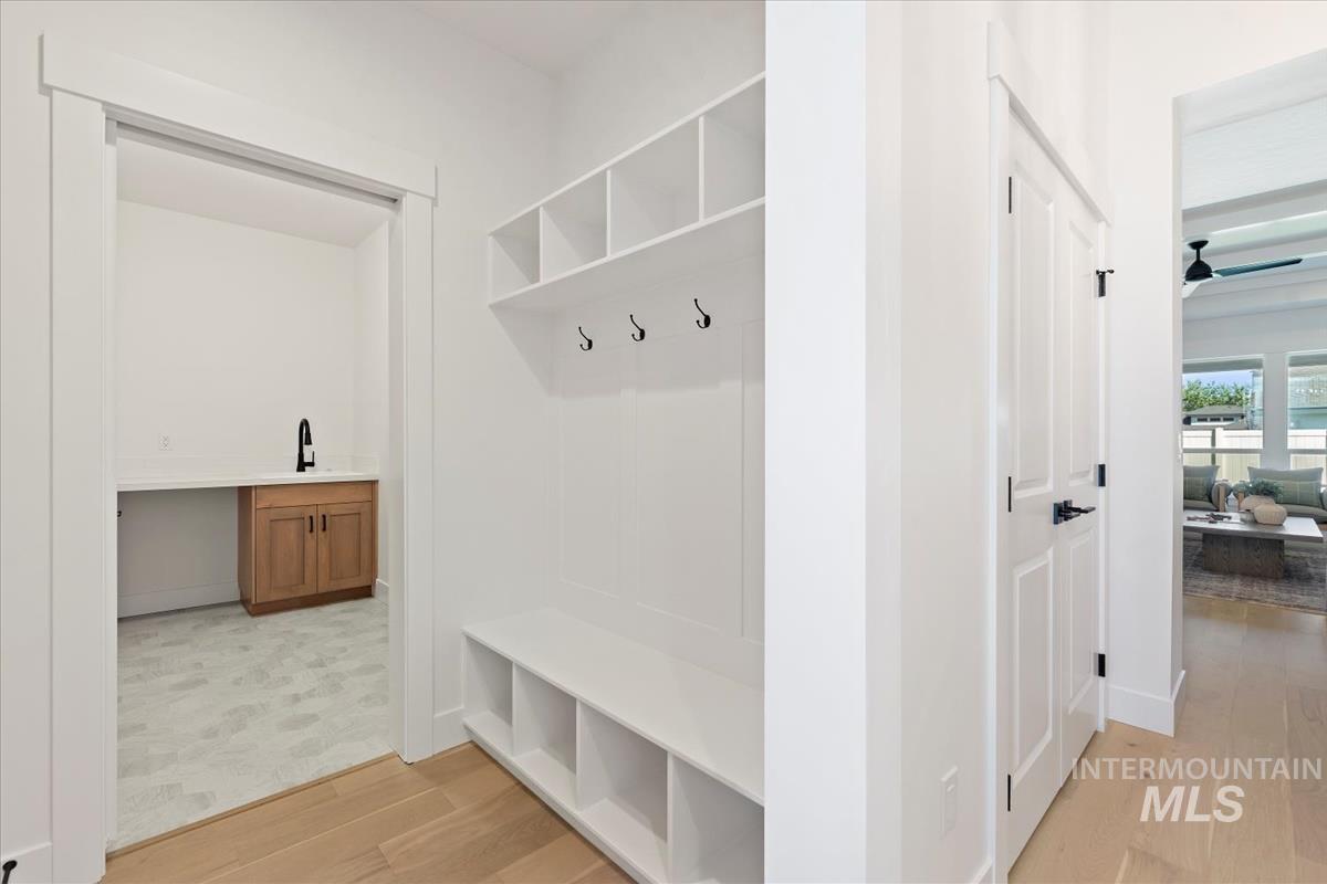 Mudroom featuring light wood-style flooring and baseboards