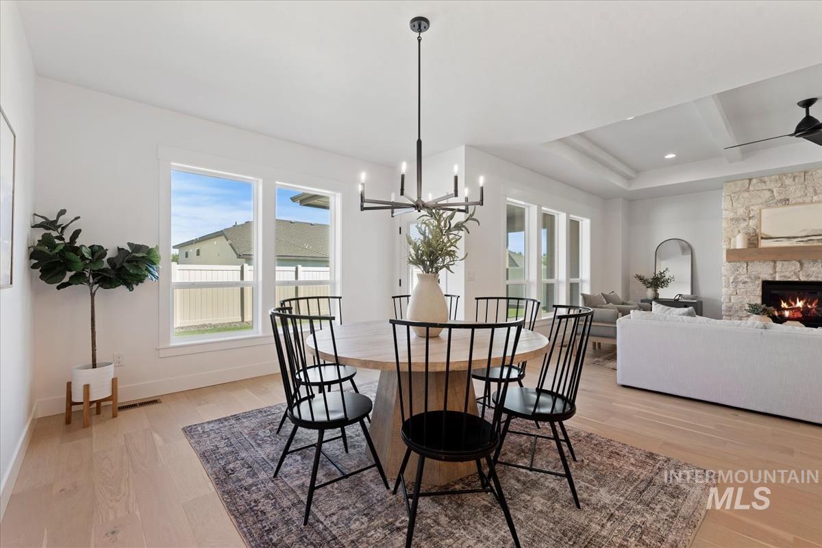 Dining area featuring light wood finished floors, a fireplace, and healthy amount of natural light