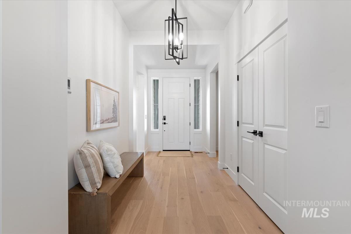 Foyer entrance featuring light wood finished floors and a chandelier