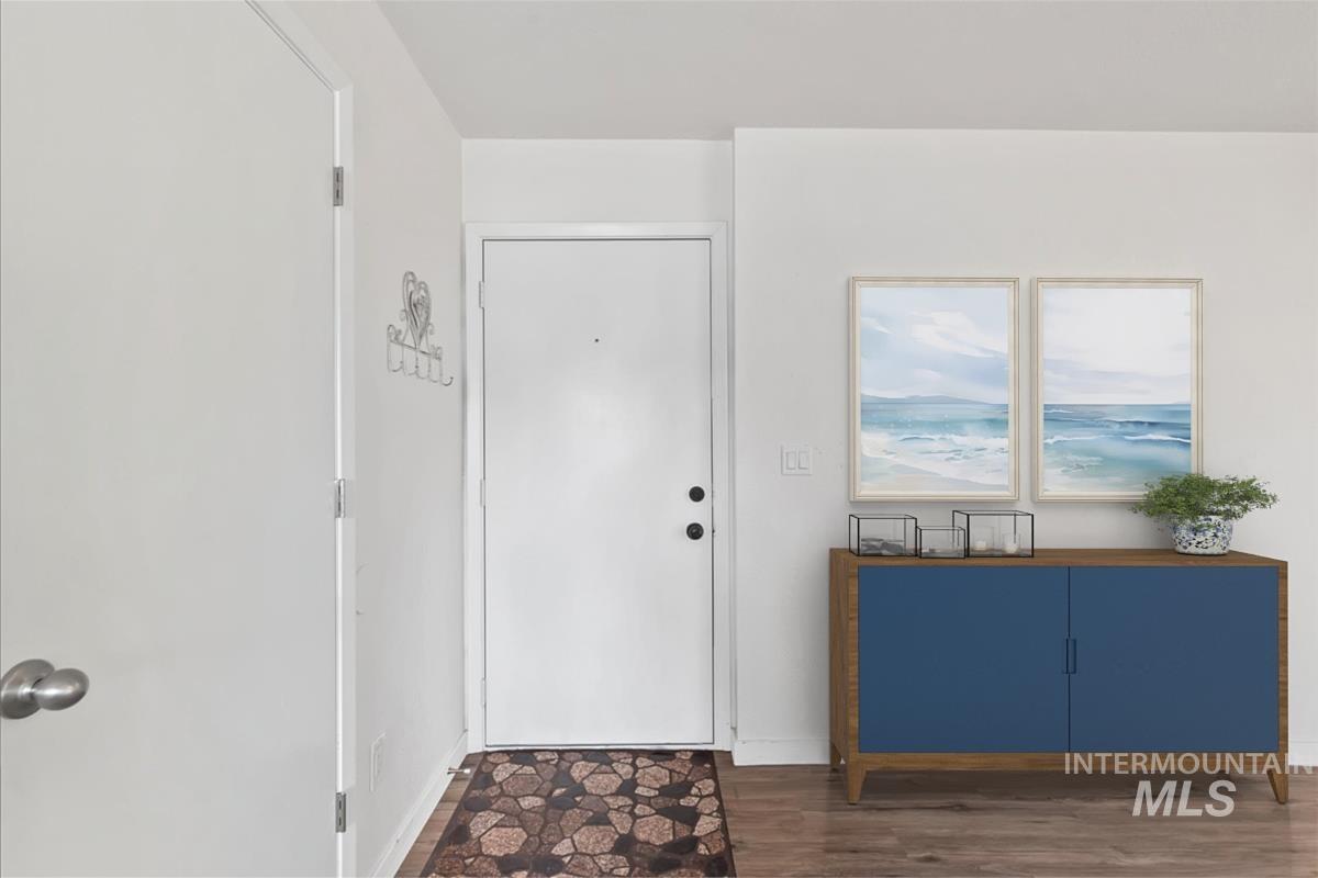 Foyer featuring dark wood-style flooring and baseboards