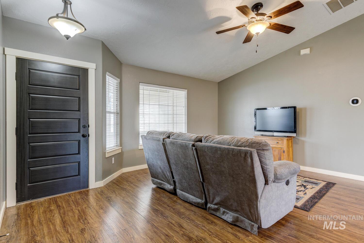Living area with wood finished floors, lofted ceiling, and ceiling fan