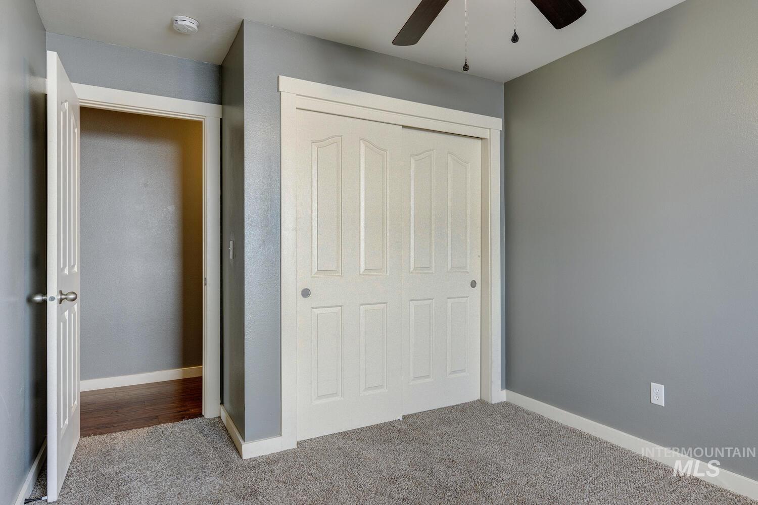 Unfurnished bedroom with carpet floors, a closet, and ceiling fan
