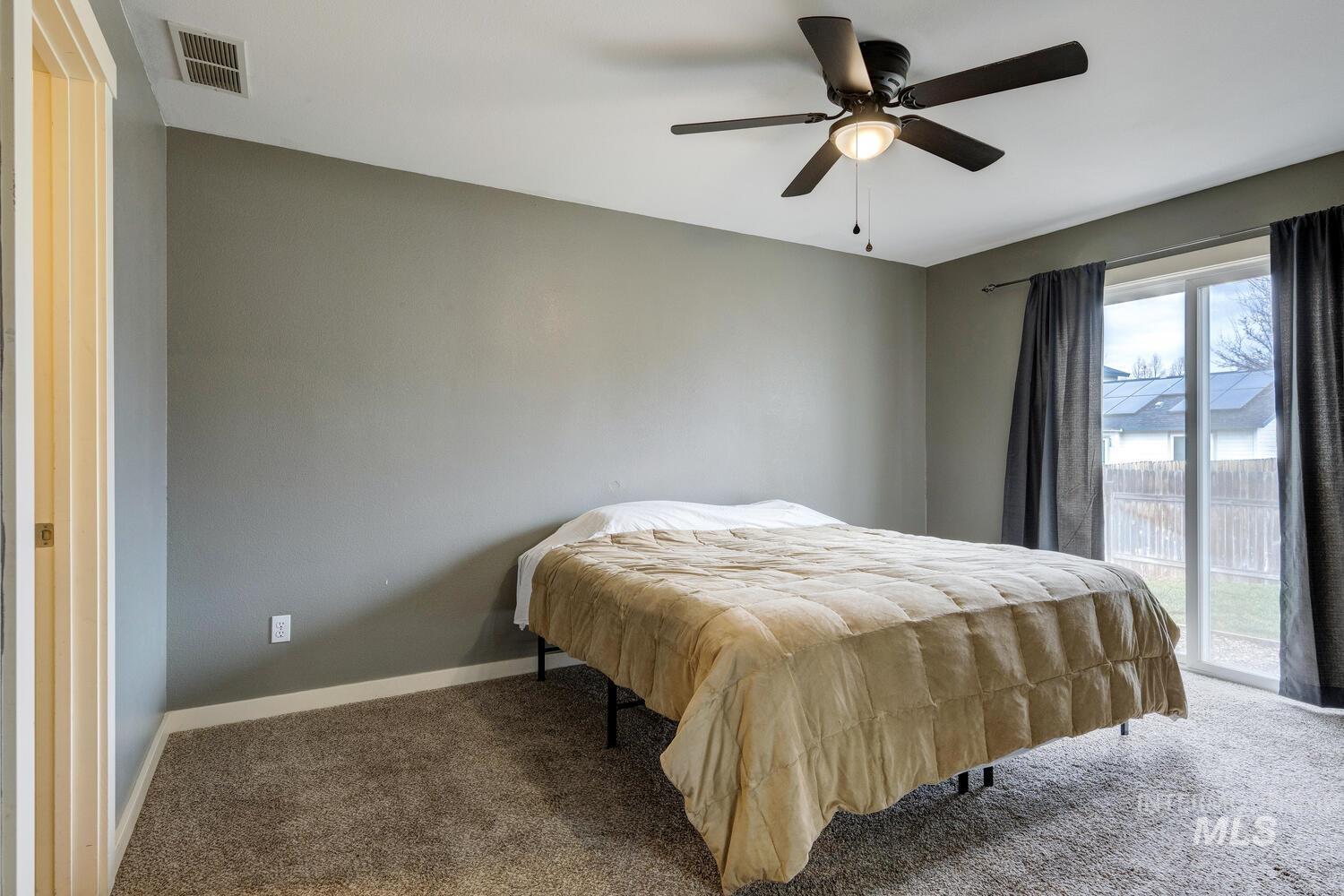 Carpeted bedroom with access to exterior and a ceiling fan