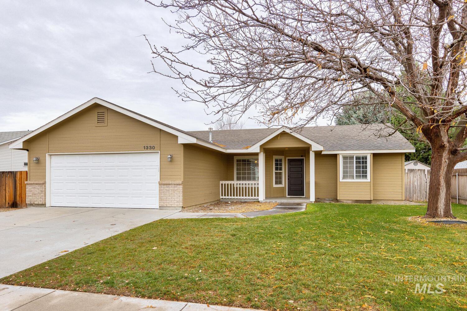 Ranch-style house with roof with shingles, driveway, a garage, and covered porch