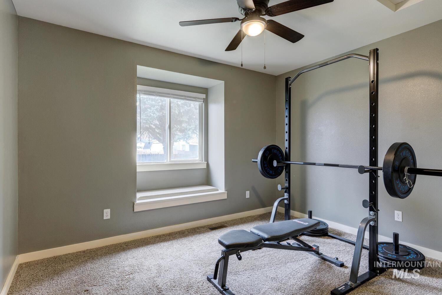 Workout area with carpet floors and ceiling fan