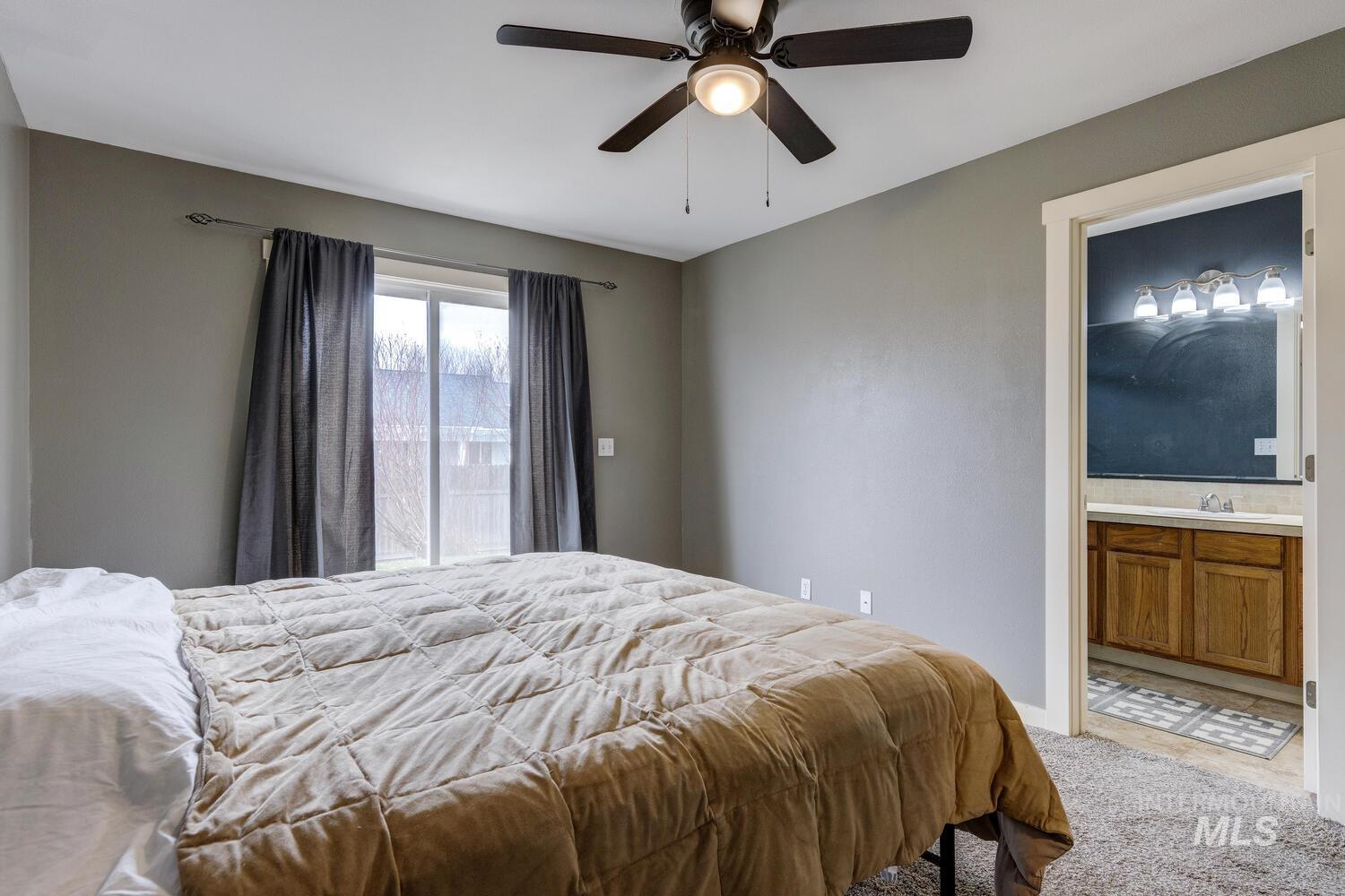 Bedroom with carpet, access to outside, ceiling fan, and ensuite bathroom