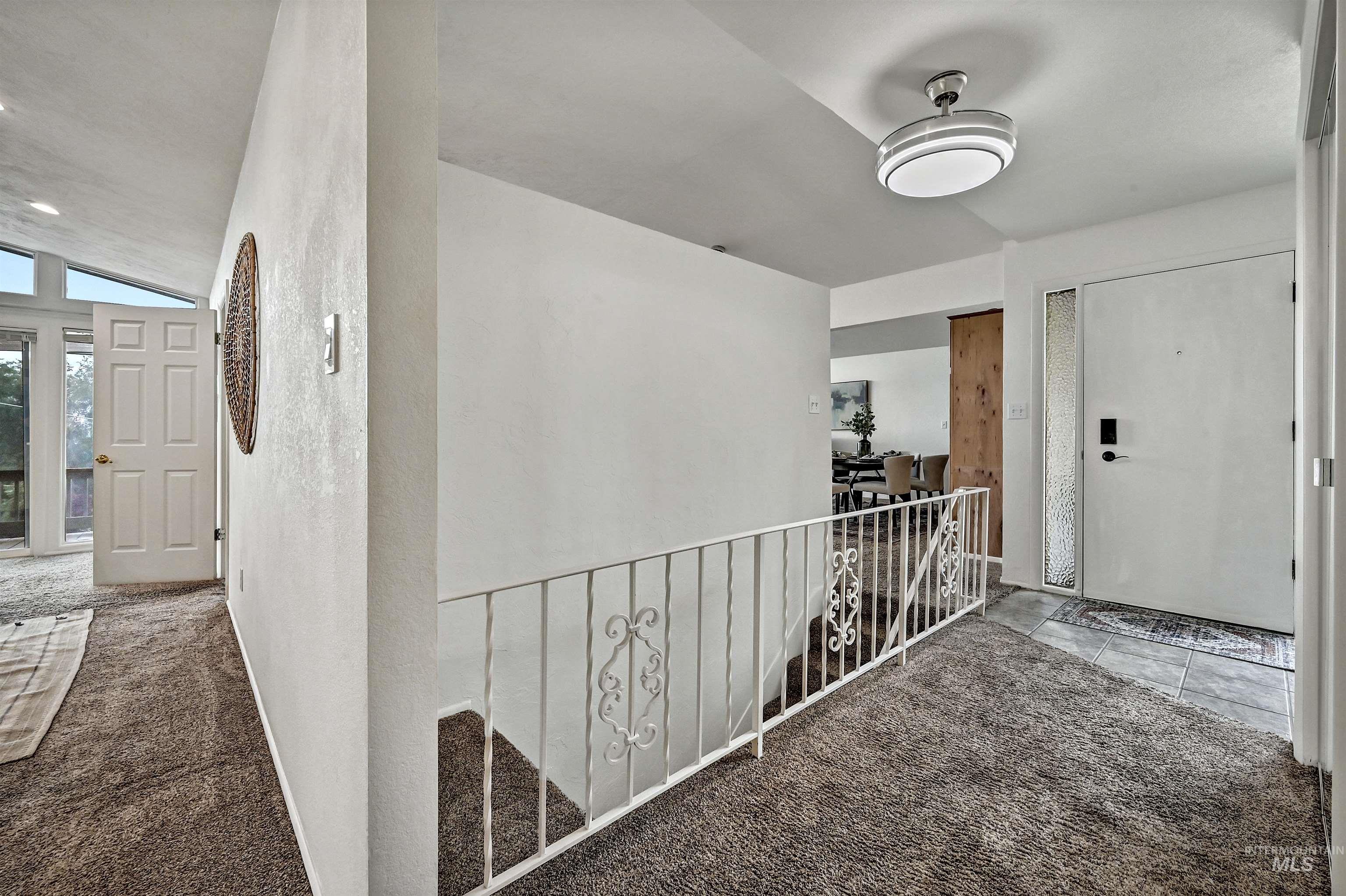 Hall featuring carpet flooring, vaulted ceiling, and an upstairs landing