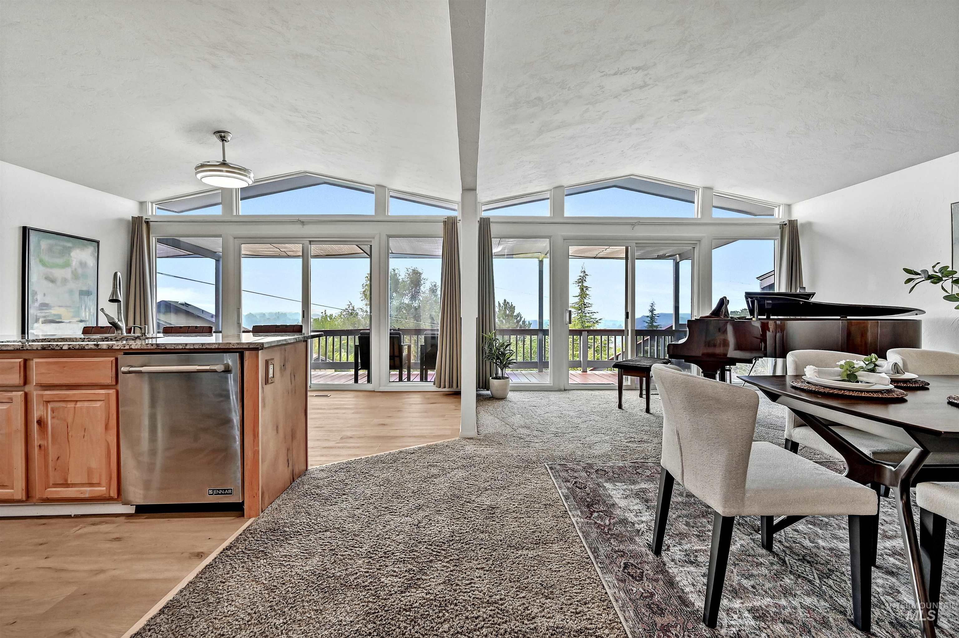 Dining room featuring lofted ceiling, light carpet, and light wood-style flooring