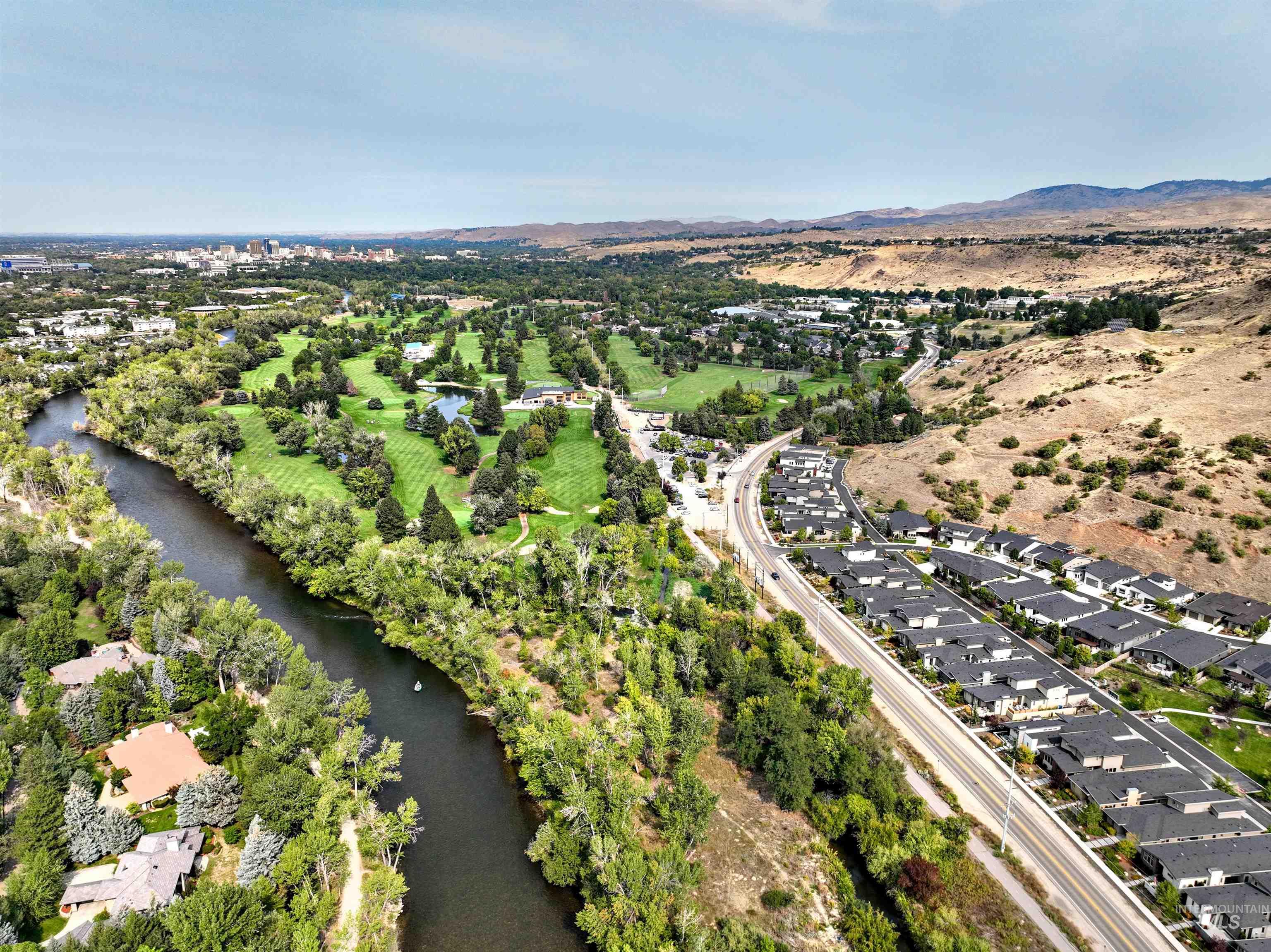 Aerial view of property and surrounding area featuring a nearby body of water and nearby suburban area