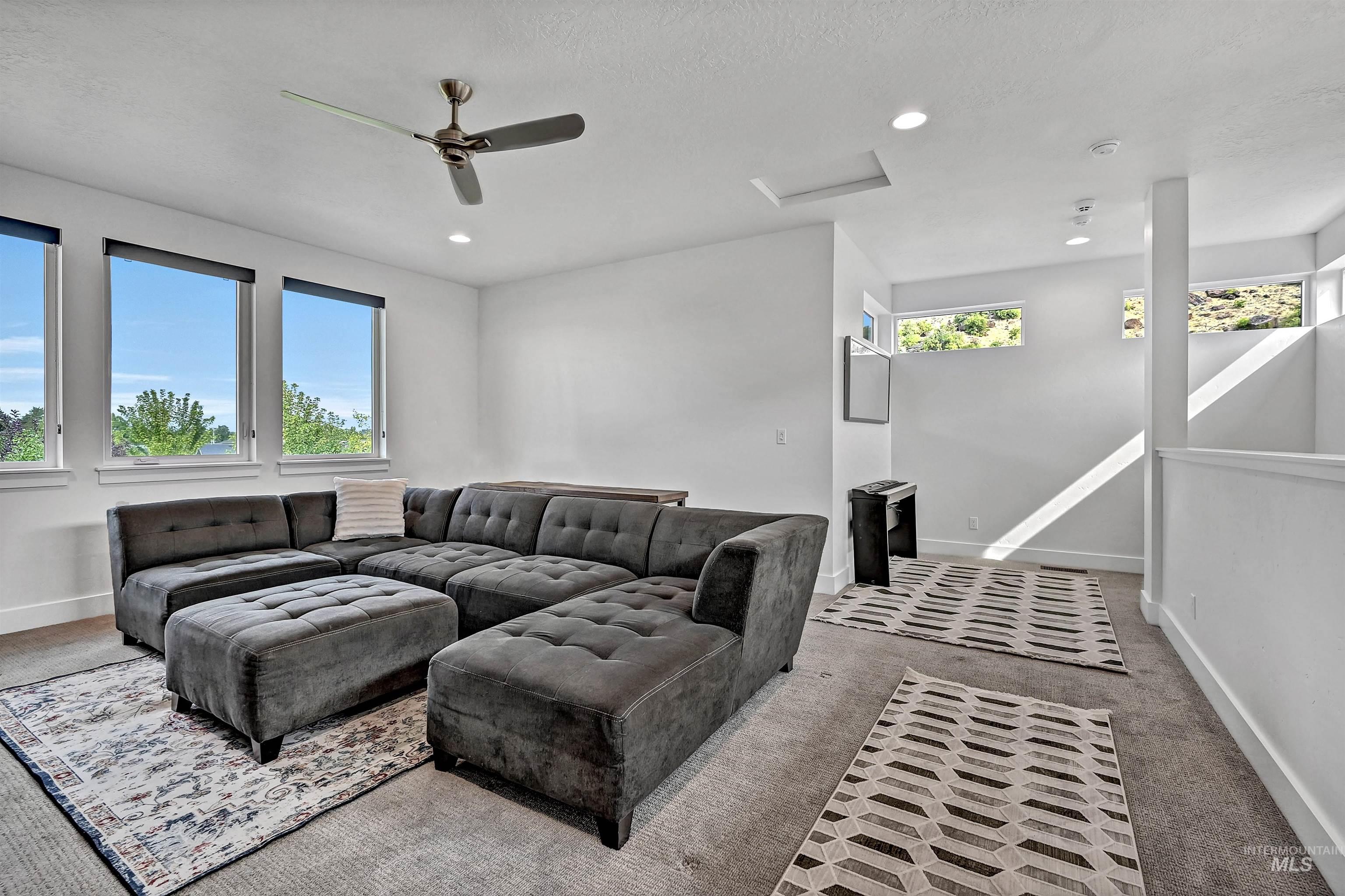 Living room with carpet floors, attic access, a ceiling fan, recessed lighting, and a textured ceiling