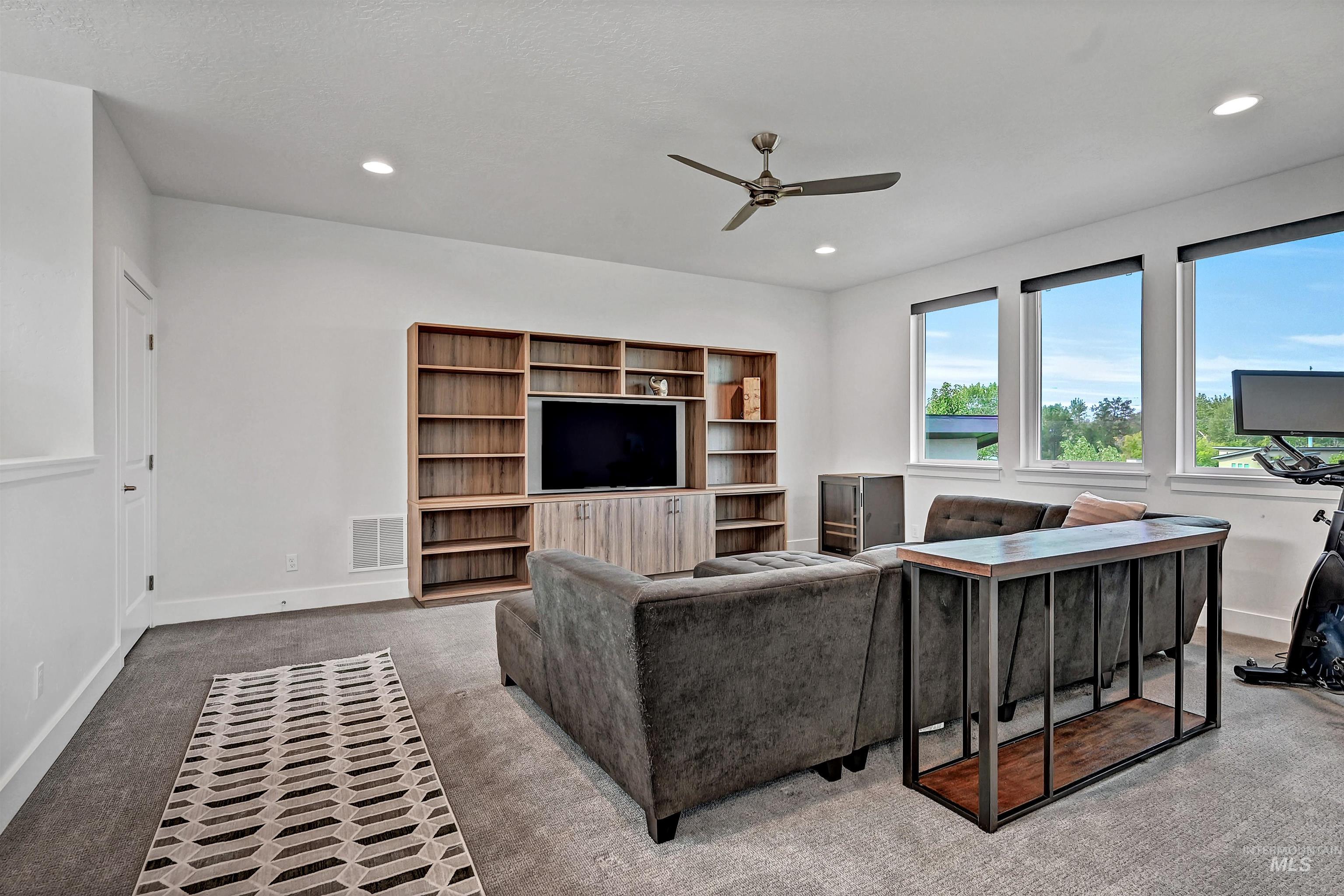 Living area featuring carpet, a ceiling fan, and recessed lighting
