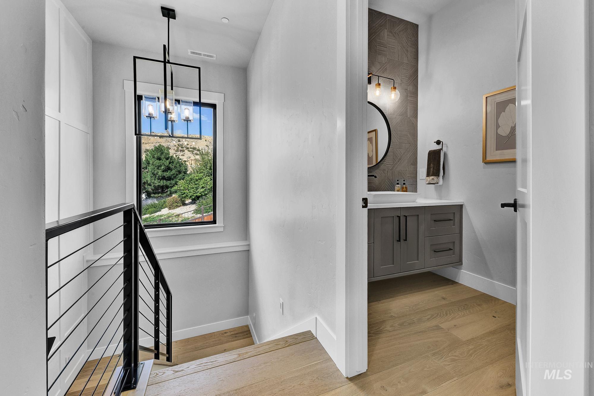 Bathroom with vanity, light wood-style floors, and a chandelier