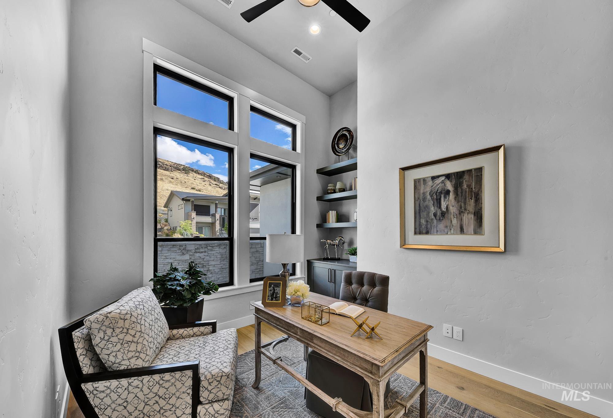 Home office featuring light wood-style flooring and a ceiling fan
