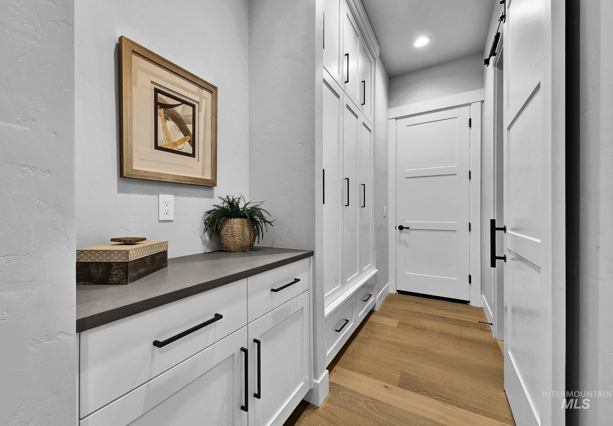 Doorway to outside featuring wood finished floors, a barn door, and recessed lighting